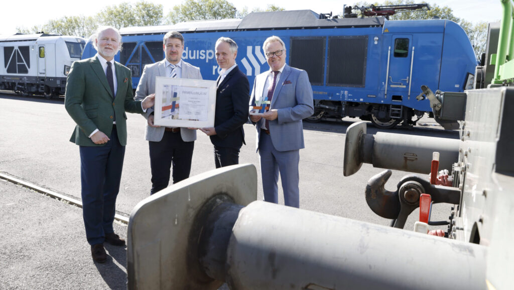 30.04.2026
Duisburg 
Übergabe Urkunde zum 25-jährigen Firmenjubiläum duisport rail GmbH 
Lars Nennhaus  duisport ( grünes Jacket ) 

Hans Georg Christiansen ,  Geschäftsführer duisport rail GmbH & Geschäftsführer Duisburger Lokservice GmbH  ( gestreifte Krawatte )  

Ocke Hamann Niederrheinische IHK Duisburg - Wesel - Kleve ( dunkles Jacket ) 

Michael Albers , Geschäftsführer duisport rail GmbH ( Brille ) 
foto: copyright  marco stepniak  -  
mobil  +49 171 2771906 ,  marco@stepniak-bild.de