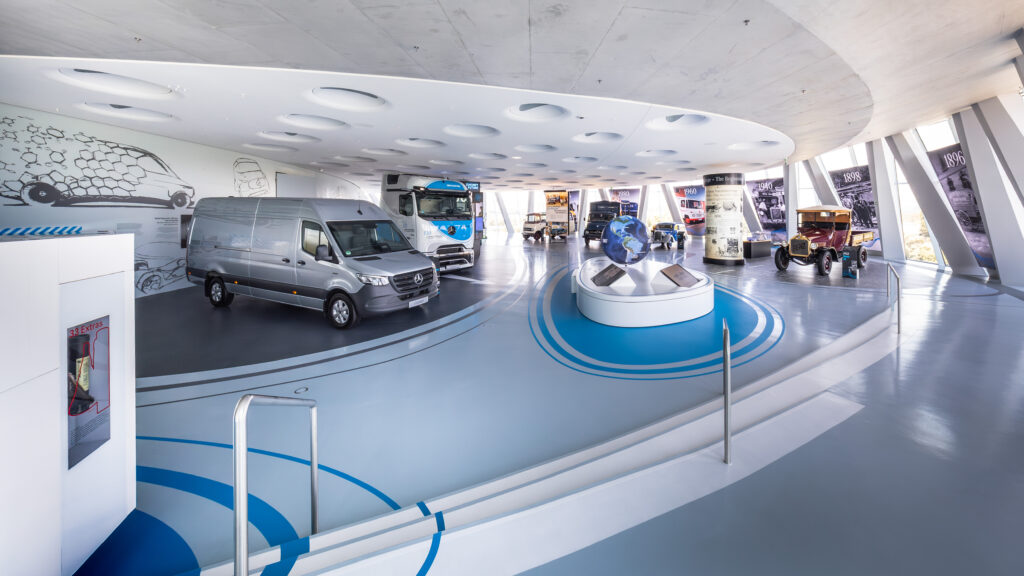 Mercedes-Benz Museum, Sonderausstellung „130 Jahre Nutzfahrzeuge“. Übersichtsaufnahme. Von links nach rechts: Mercedes-Benz eSprinter (2024), Mercedes-Benz eActros 600 (2024), Mercedes-Benz O 319 D Panoramabus (1961), Mercedes-Benz L 911 Kurzhauber-Lkw (1966), Mercedes-Benz 170 V Servicefahrzeug (1952) und Benz 1C (1922). Foto: Dirk Weyhenmeyer. 

Mercedes-Benz Museum, special exhibition “130 Years of Commercial Vehicles”. Overview shot. From left to right: Mercedes-Benz eSprinter (2024), Mercedes-Benz eActros 600 (2024), Mercedes-Benz O 319 D panoramic coach (1961), Mercedes-Benz L 911 short-bonnet lorry (1966), Mercedes-Benz 170 V service vehicle (1952) and Benz 1C (1922). Photo: Dirk Weyhenmeyer.